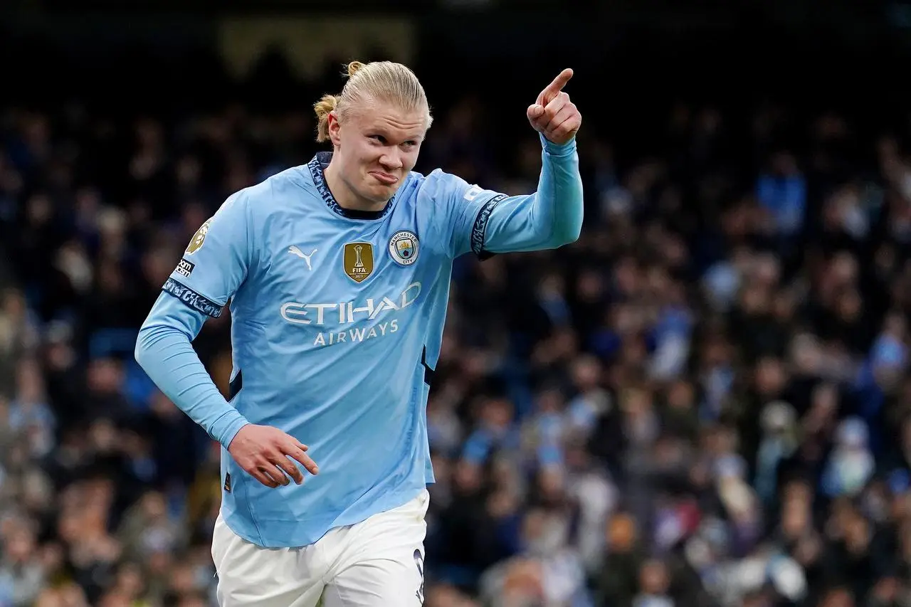 Erling Haaland celebrates a goal by raising his arm in the air