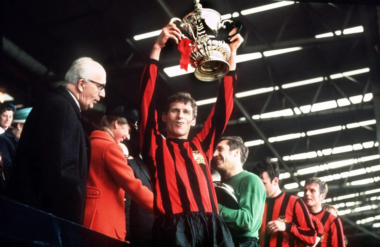 Manchester City captain Tony Book lifts the FA Cup after their victory in the 1969 final