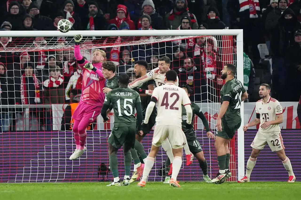 Celtic goalkeeper Kasper Schmeichel, left, punches the ball clear against Bayern Munich