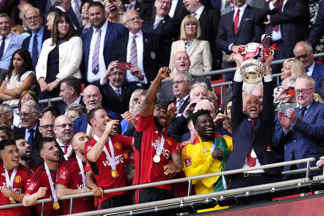 Erik ten Hag lifts the trophy in the stands at Wembley after Manchester United's FA Cup win