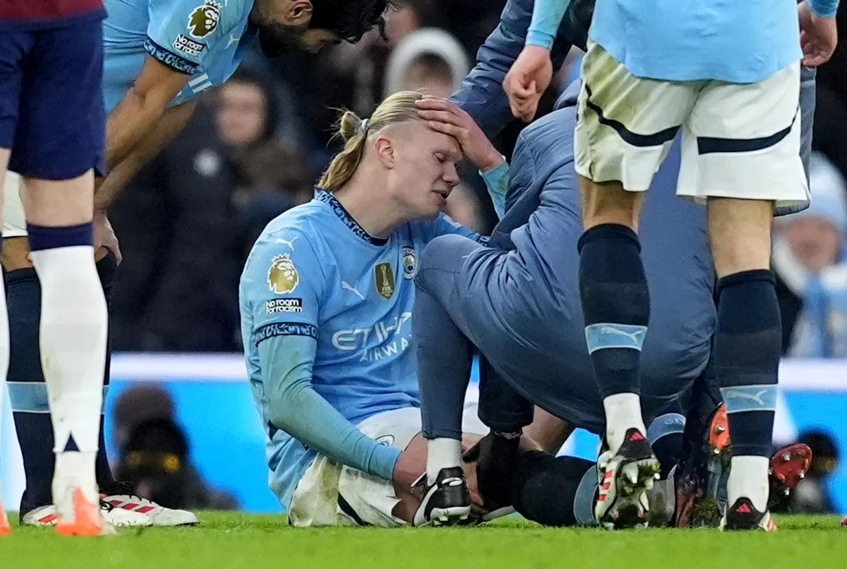 Manchester City striker Erling Haaland sits injured on the pitch against Newcastle