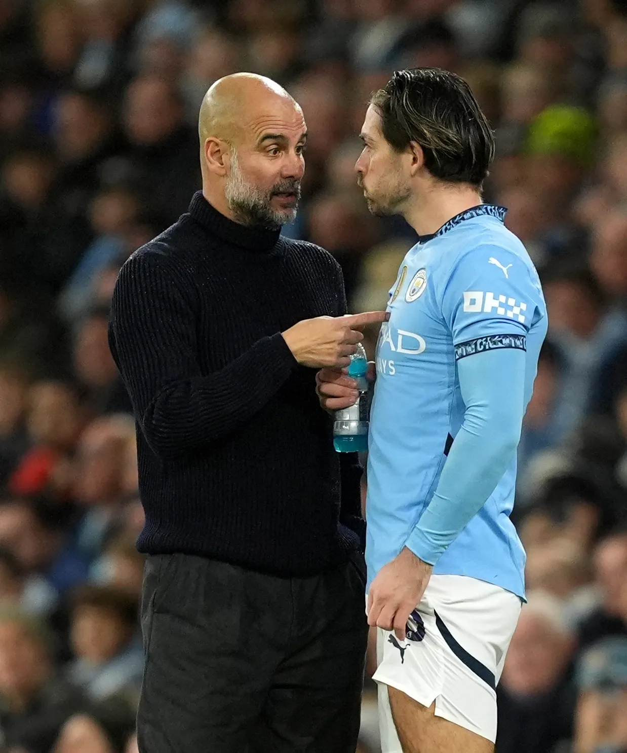 Pep Guardiola gives instructions to Manchester City substitute Jack Grealish during a game against Tottenham