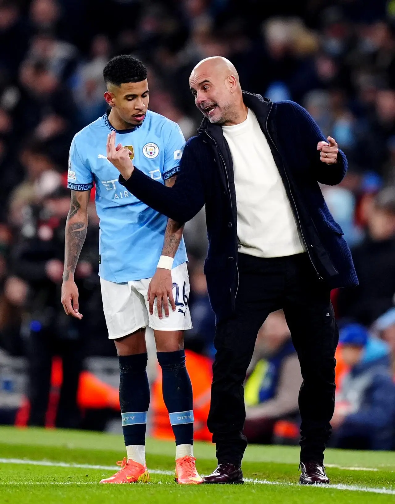 Manchester City manager Pep Guardiola, right, passes on instructions to Savinho