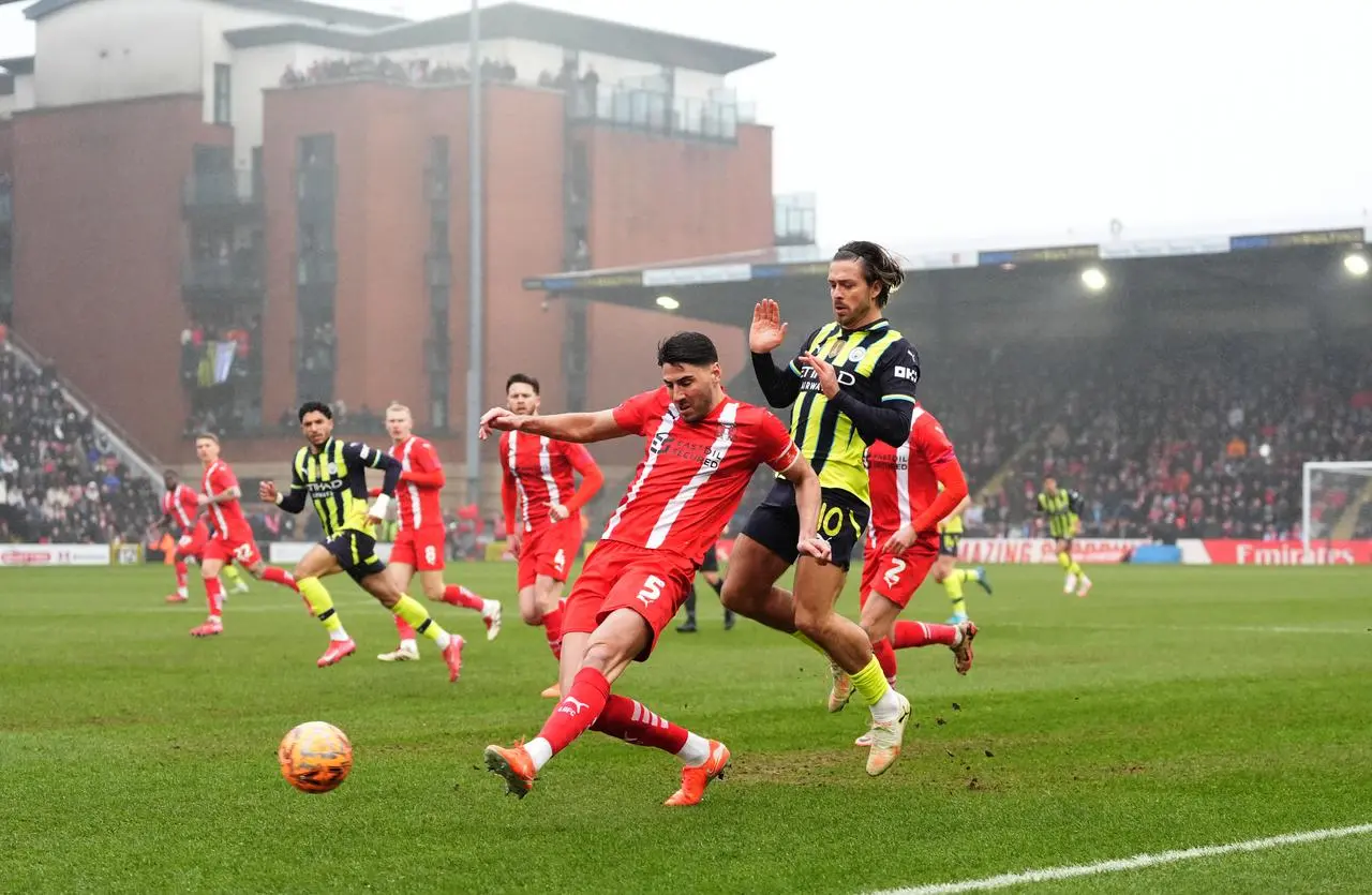 Manchester City’s Jack Grealish, right, battles for possession with Leyton Orient’s Dan Happe