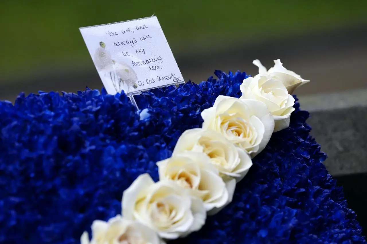 Detail of the card on flowers sent by Rod Stewart to Denis Law's funeral. The flowers form a large Scottish flag and the card reads 'You are, and always will be, my footballing hero. Sir Rod Stewart'