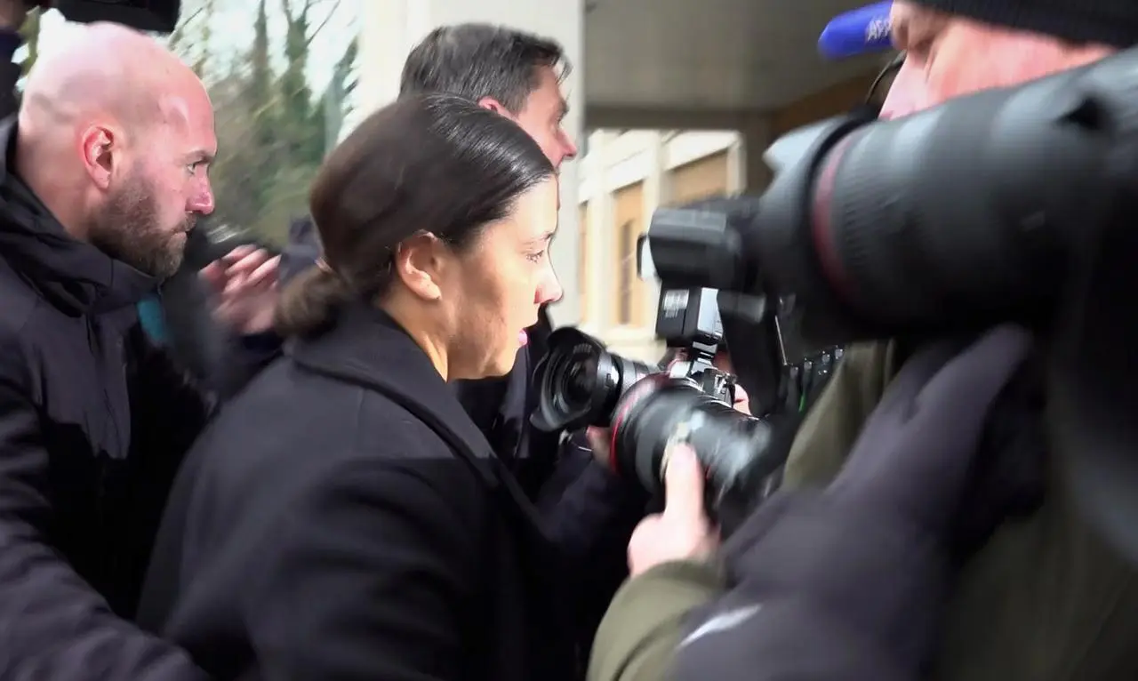 Sam Kerr walks into court as photographers take photos