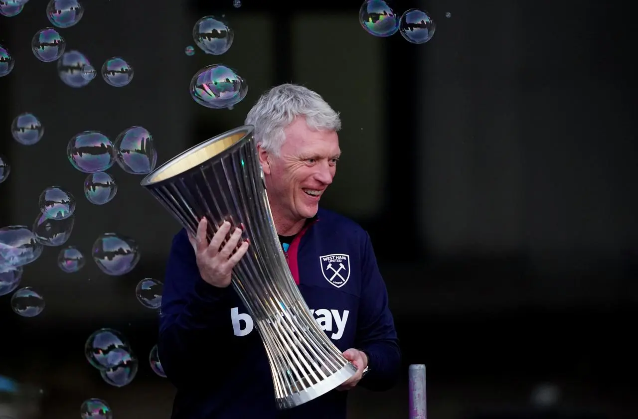 David Moyes celebrates with the trophy as bubbles blow during West Ham's Conference League victory parade