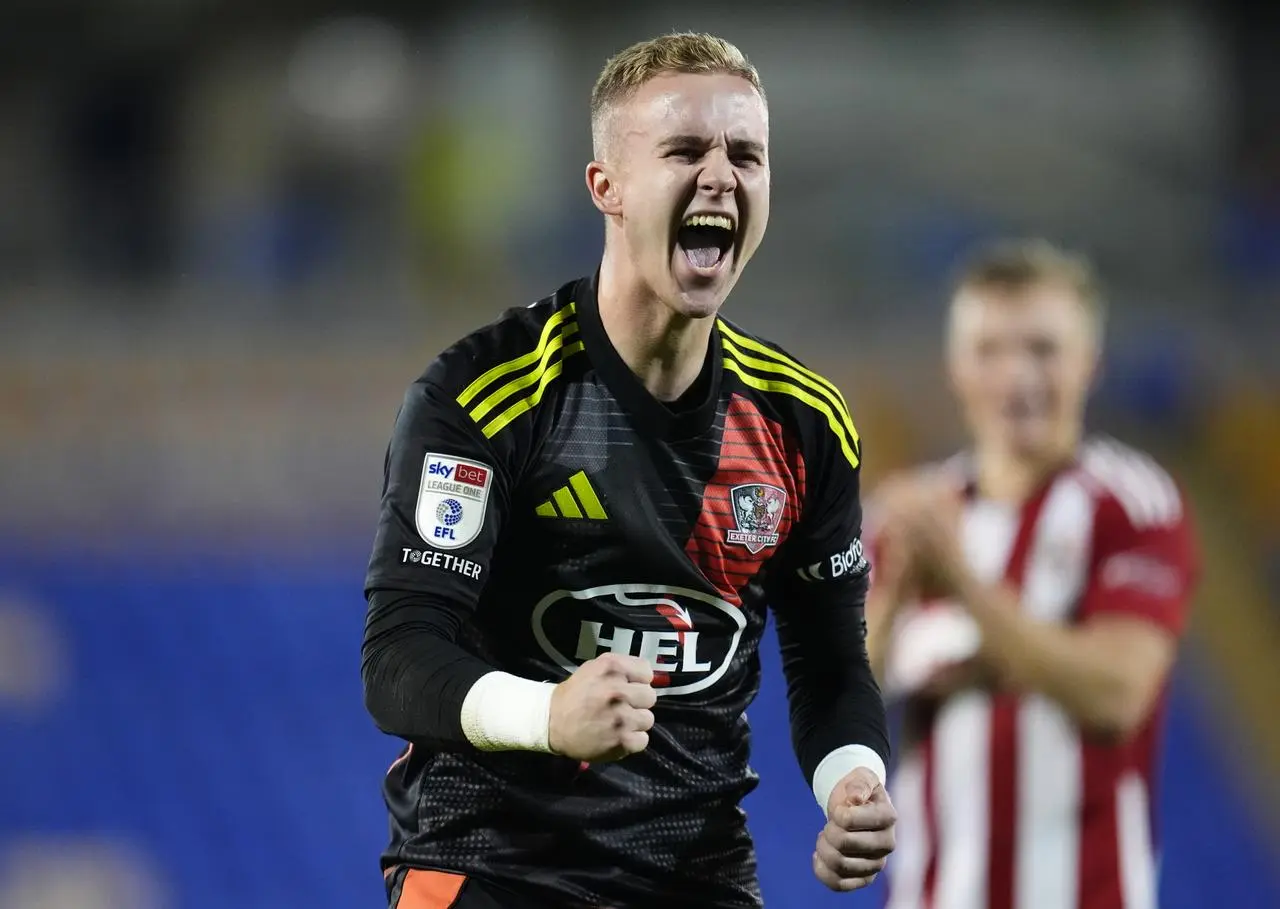 Exeter City goalkeeper Joe Whitworth celebrates in front of the fans