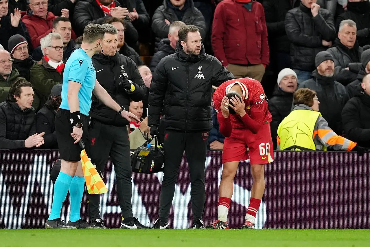 Liverpool’s Trent Alexander-Arnold, right, puts his head in his hands after his injury against Paris St Germain