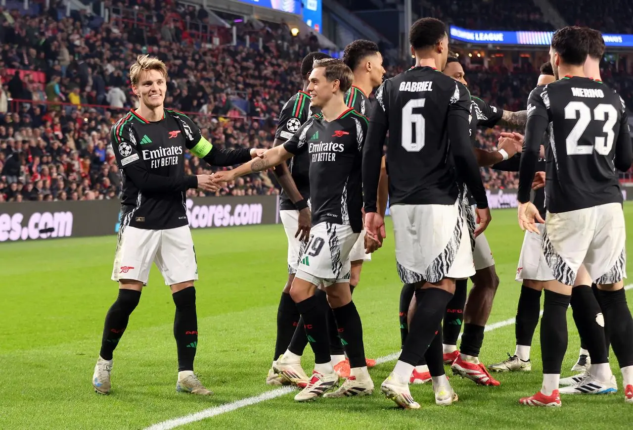 Martin Odegaard, left, celebrates with team-mates after scoring his first goal and Arsenal’s fourth in Eindhoven