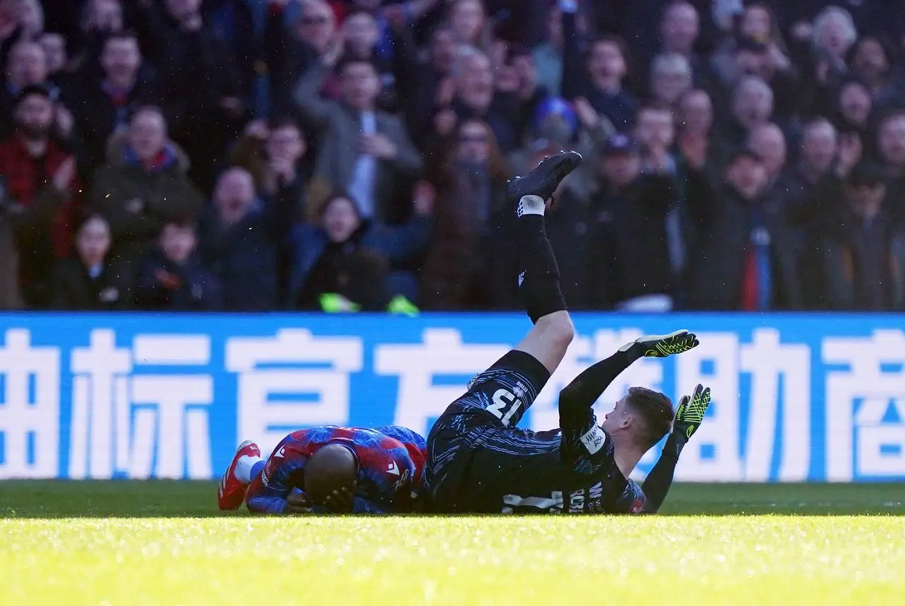 Millwall goalkeeper Liam Roberts on the floor with Jean-Philippe Mateta holding his head after the pair collided