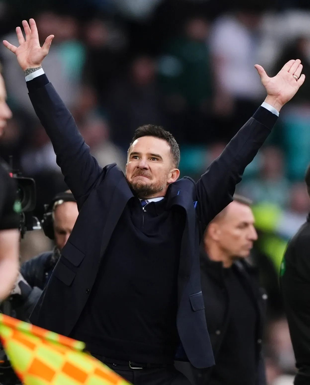 Rangers interim head coach Barry Ferguson celebrates at Celtic Park with Brendan Rodgers in the background 