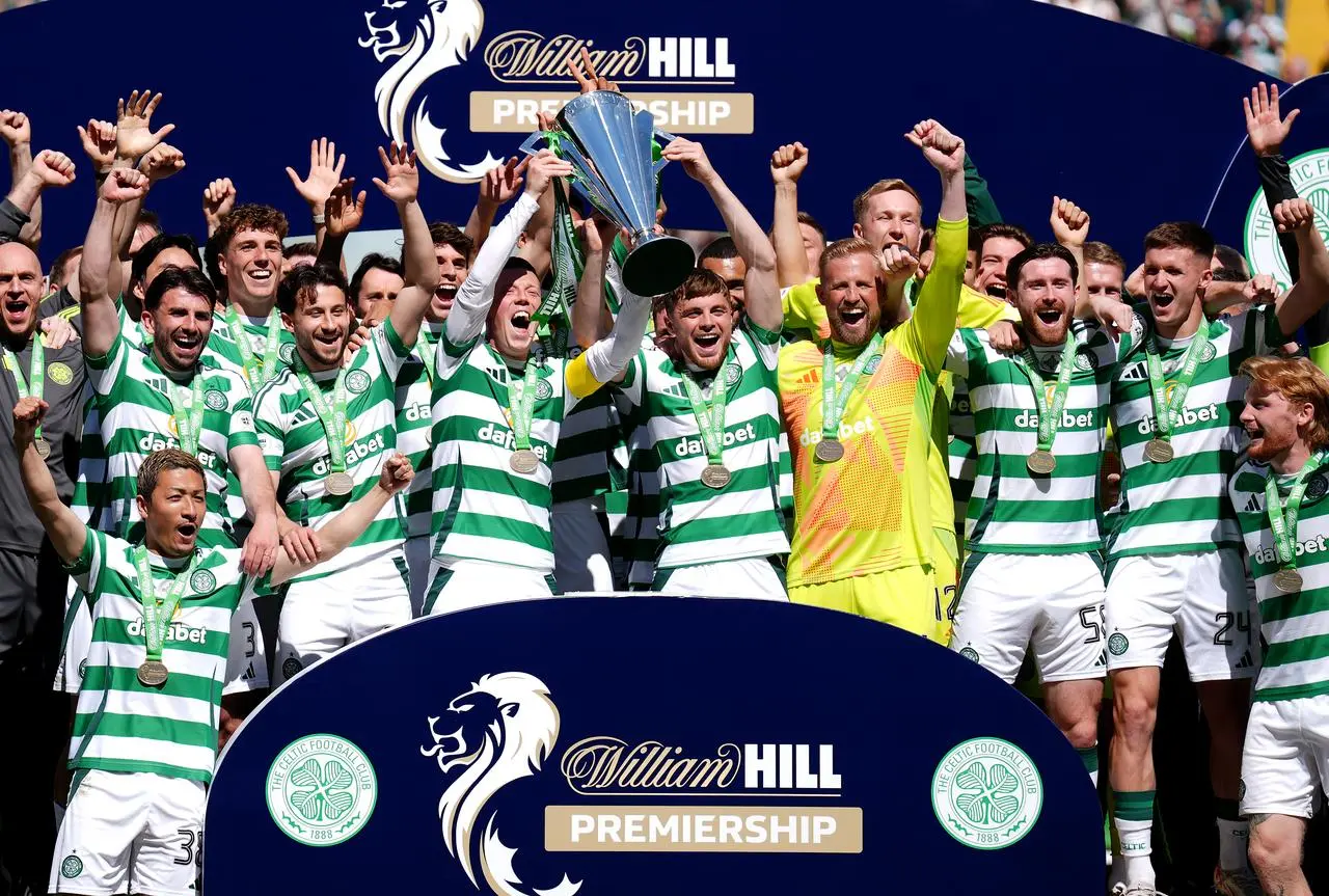 Celtic captain Callum McGregor lifts the league trophy with his team-mates beside him