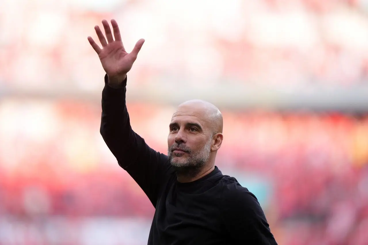 Pep Guardiola waves to the crowd at Wembley Stadium.