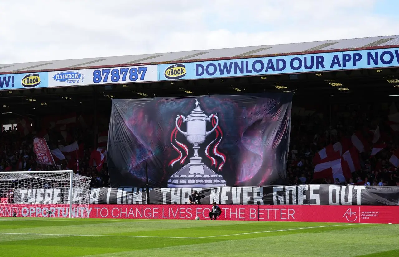 Aberdeen fans hold up a banner celebrating their Scottish Cup triumph before kick-off against Celtic
