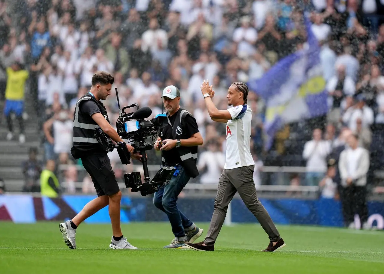 Xavi Simons waves to the crowd as he is followed by a cameraman