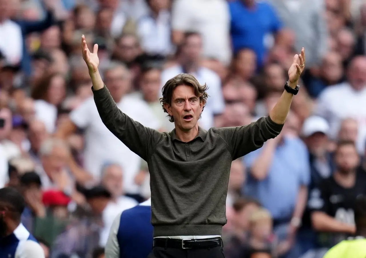 Thomas Frank throws his arms up into the air