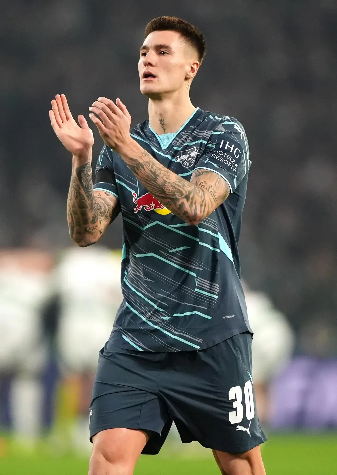 Benjamin Sesko applauds on a football field 