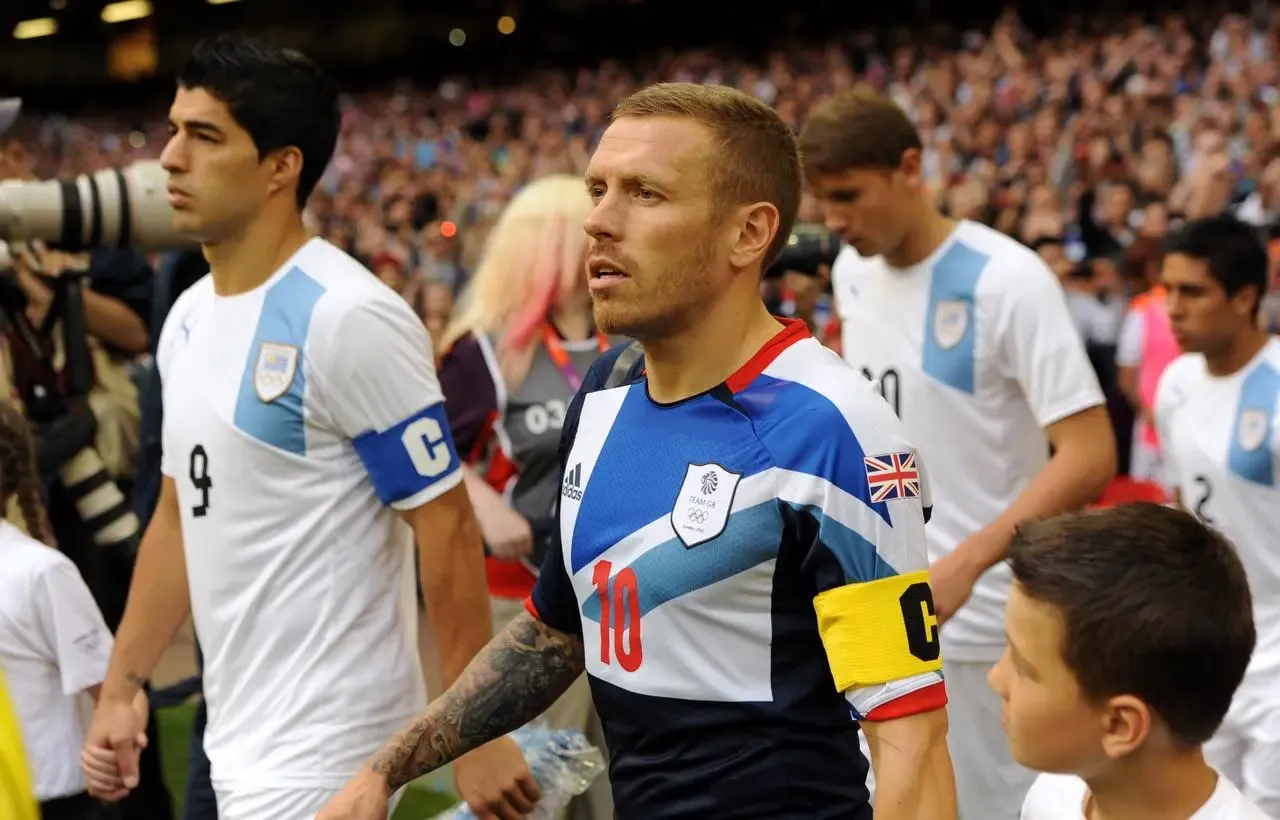 Criag Bellamy, right, leads out Team GB alongside Uruguay captain Luis Suarez at the London 2012 Olympics