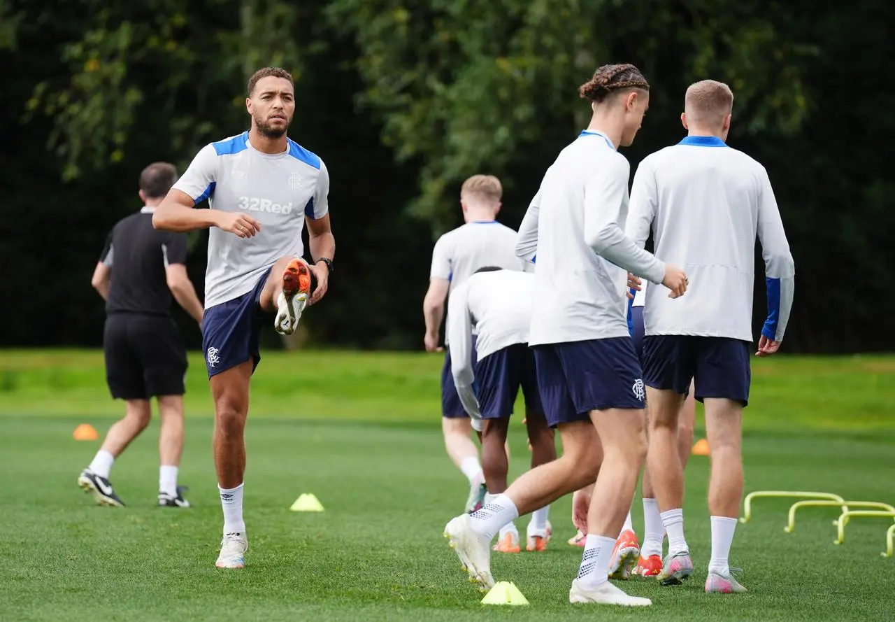 Cyriel Dessers, left, warms up during a training session