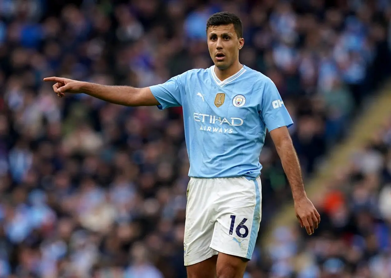 Manchester City midfielder Rodri points with his right arm