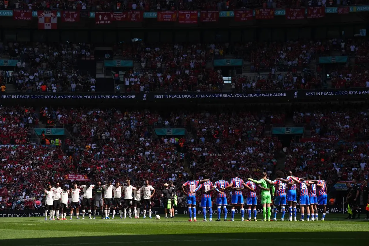 Liverpool and Crystal Palace stand during a minute's silence