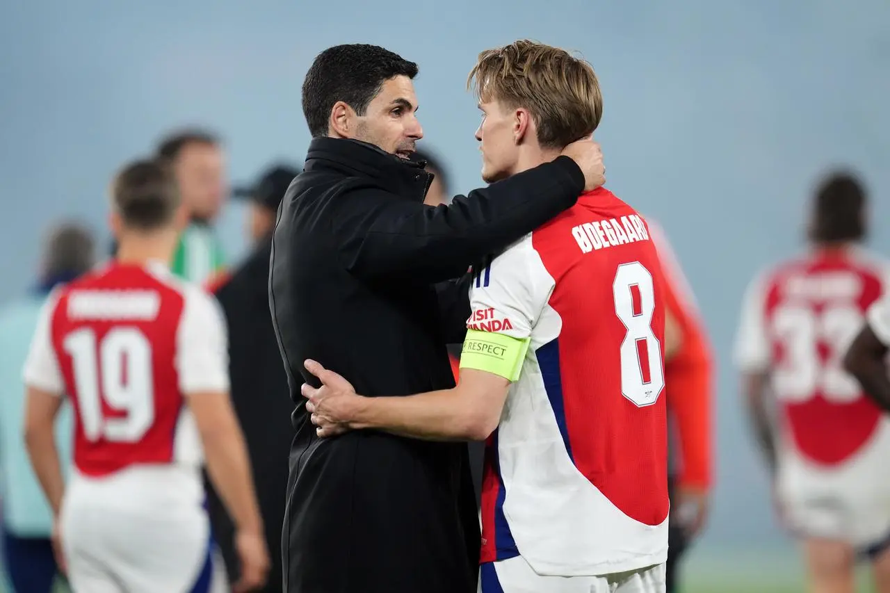 Mikel Arteta, left, embraces Martin Odegaard 