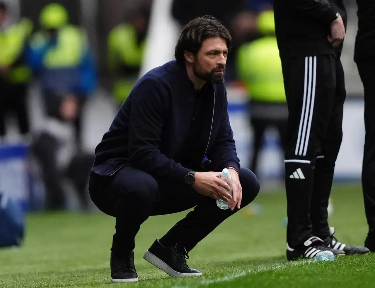 Russell Martin crouches down on the touchline