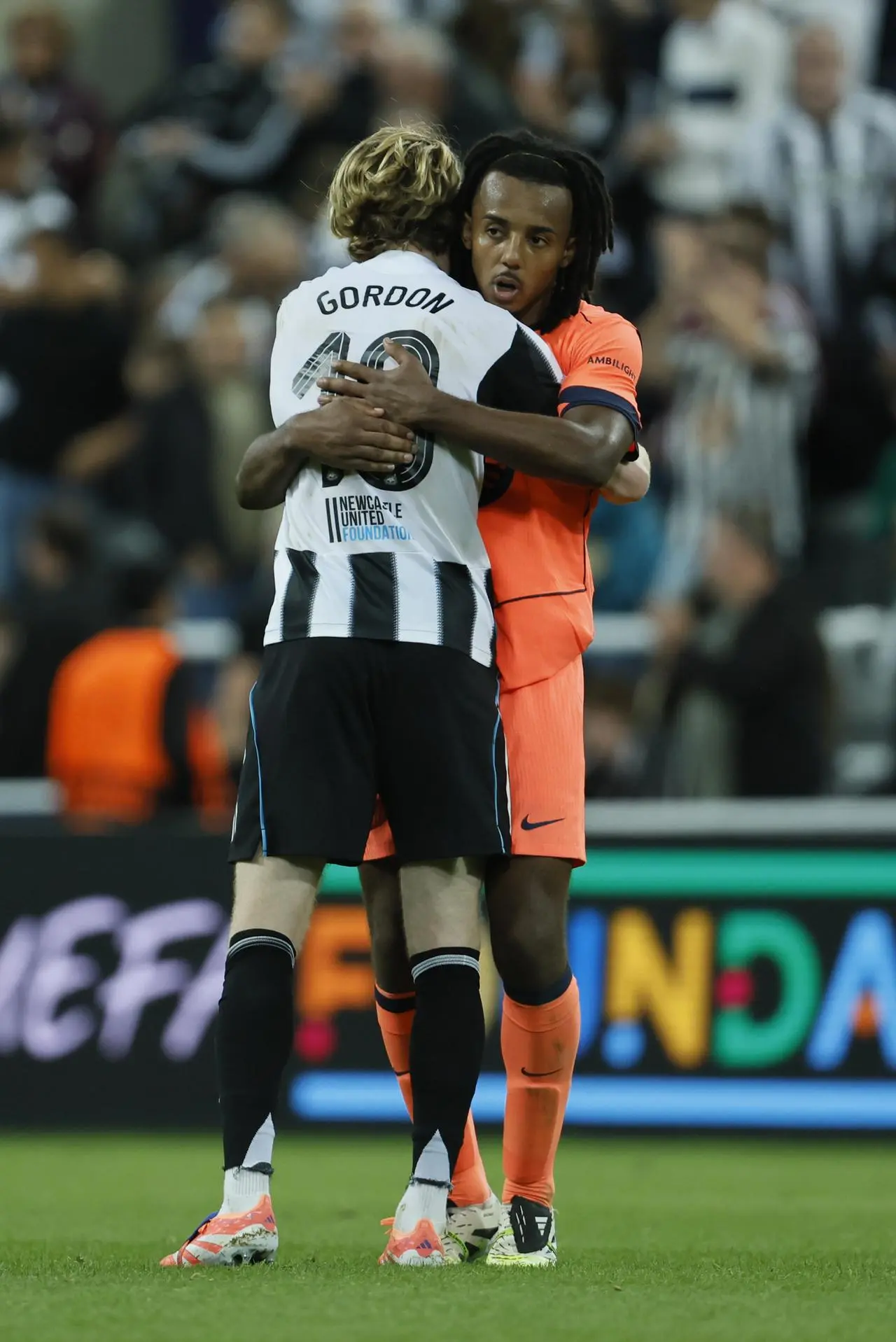 Newcastle’s Anthony Gordon and Barcelona’s Jules Kounde embrace after the final whistle