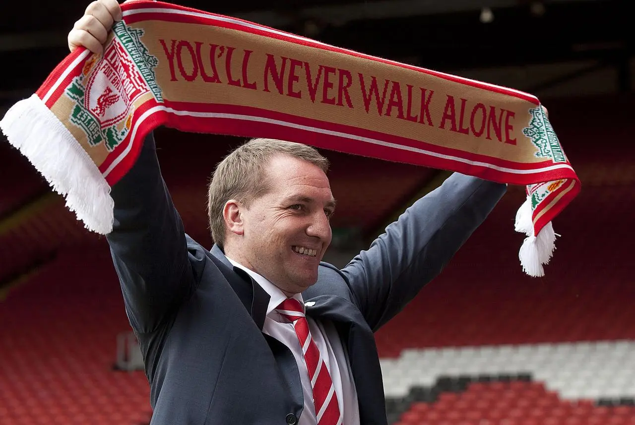 Brendan Rodgers holds a Liverpool scarf above his head on his first day as Anfield manager