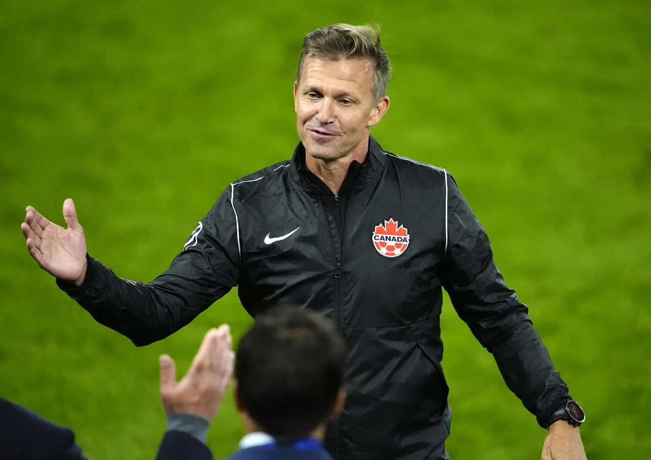 Canada manager Jesse Marsch celebrates with a member of his coaching staff