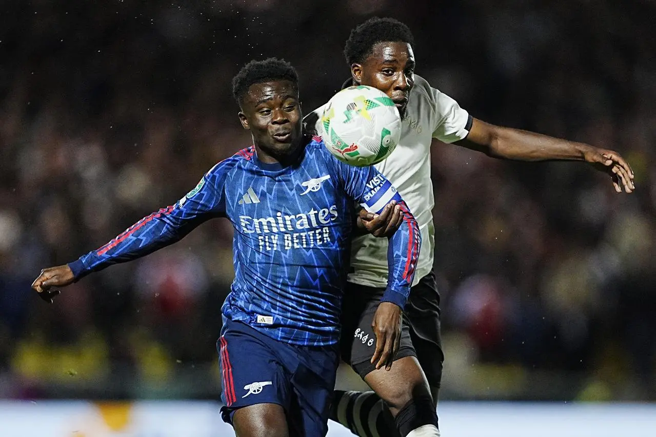Arsenal’s Bukayo Saka is challenged by Port Vale’s Jaheim Headley