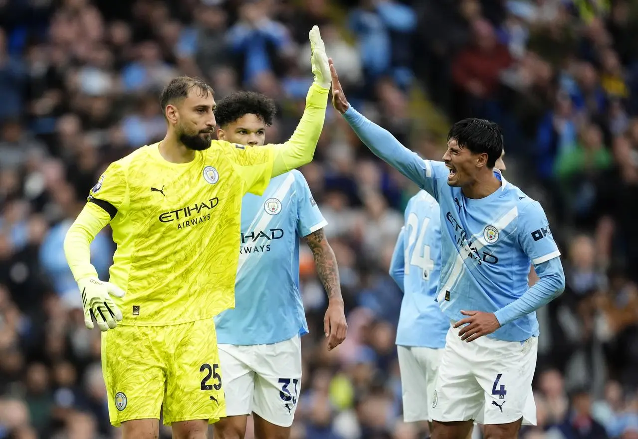 Manchester City’s Tijjani Reijnders, right, high-fives goalkeeper Gianluigi Donnarumma after a save