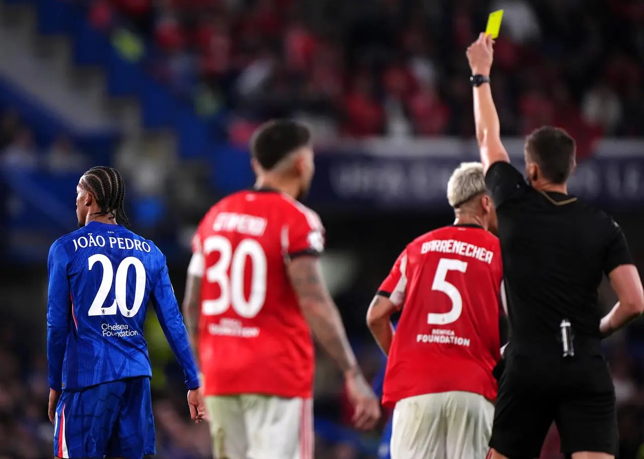 Chelsea’s Joao Pedro, left, is shown a second yellow card by referee Daniel Siebert, right, against Benfica