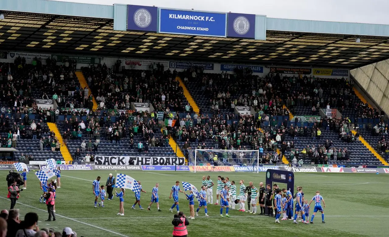 Celtic fans in a half-empty stand display a banner reading 'Sack the Board' ahead of kick-off
