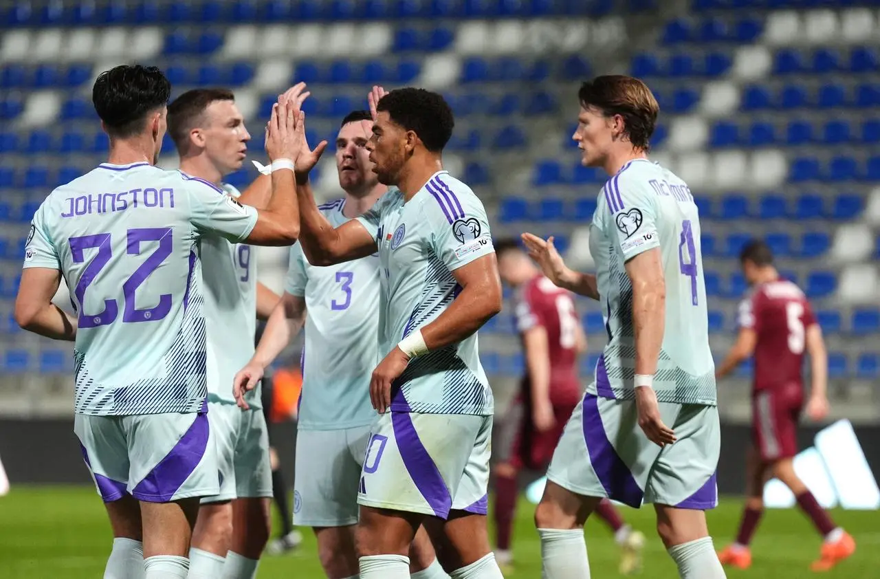 Scotland’s Che Adams (centre) celebrates with his team-mates