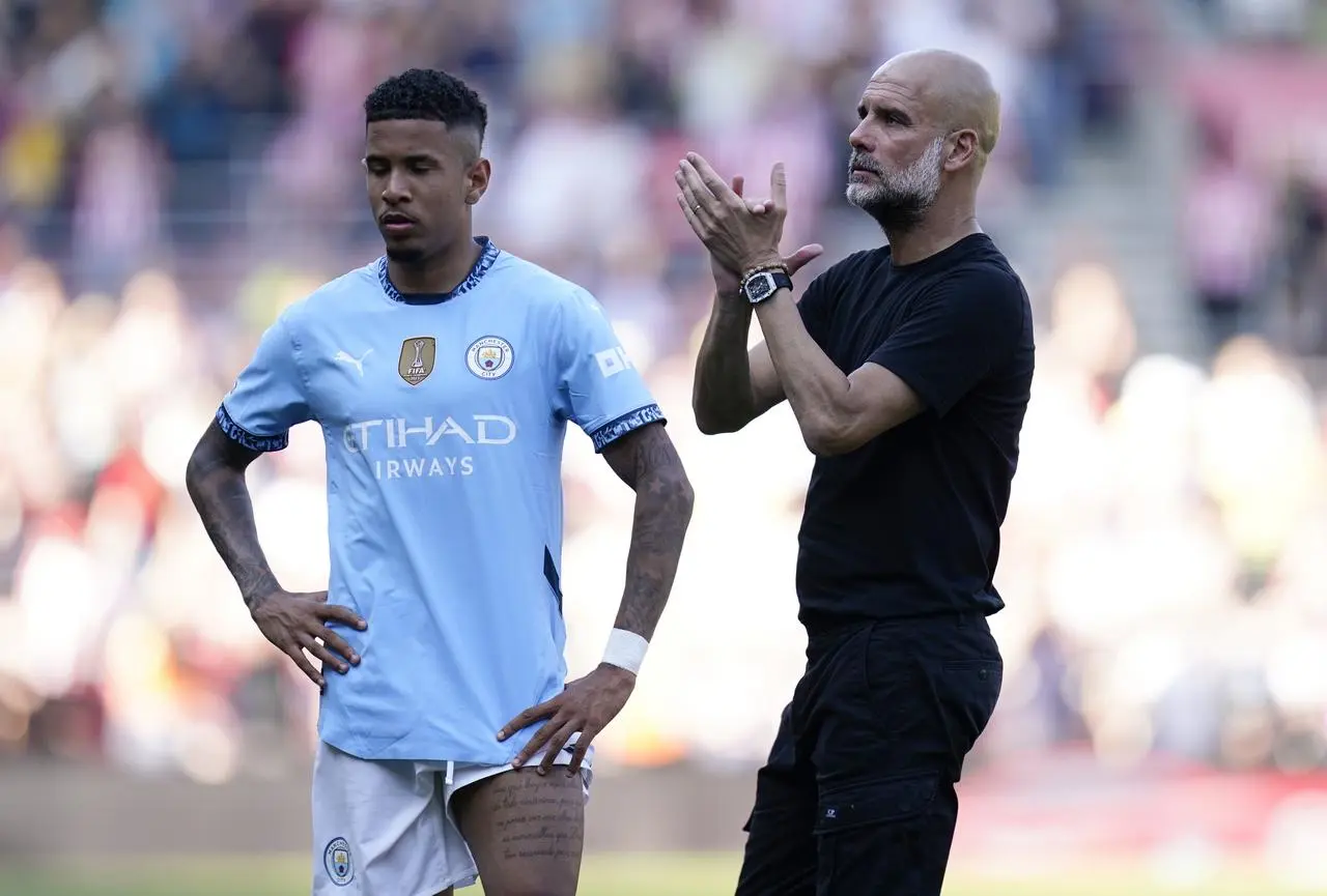 Manchester City manager Pep Guardiola, with Savinho, applauds the fans