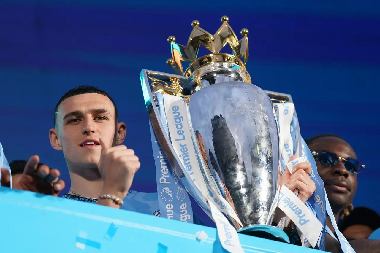 Phil Foden with the Premier League trophy during Manchester City's open-top bus parade in 2024