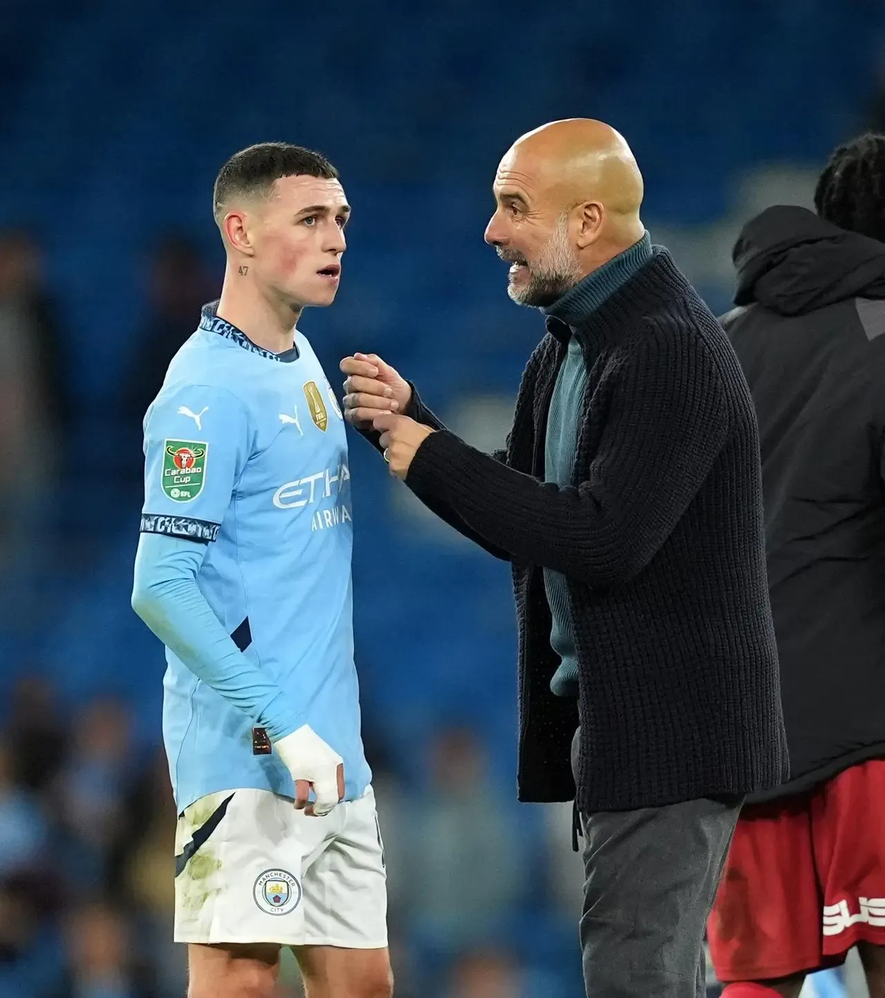 Manchester City manager Pep Guardiola speaks to Phil Foden during a game