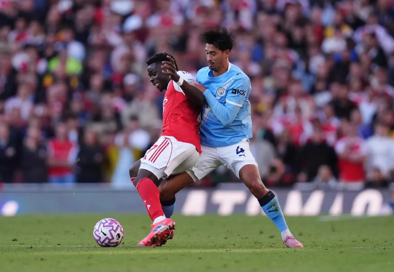 Arsenal’s Bukayo Saka and Manchester City’s Tijjani Reijnders battle for the ball 