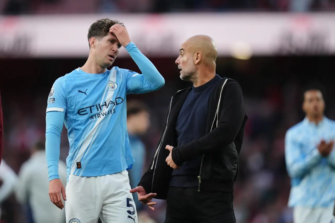 Pep Guardiola in discussion with John Stones