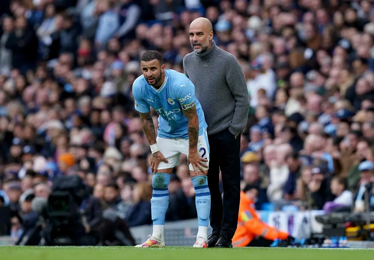 Manchester City manager Pep Guardiola speaks with Kyle Walker, wearing the captain's armband