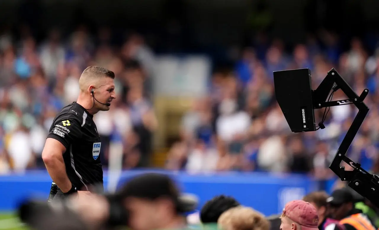 Referee Rob Jones views the VAR monitor at Stamford Bridge