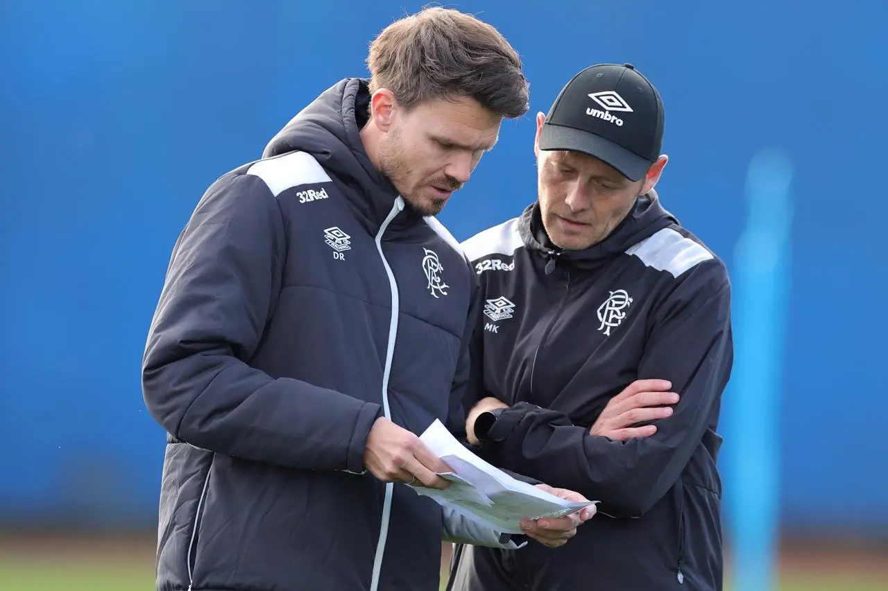 Danny Rohl, left, studies a sheet of paper with assistant coach Matthias Kaltenbach