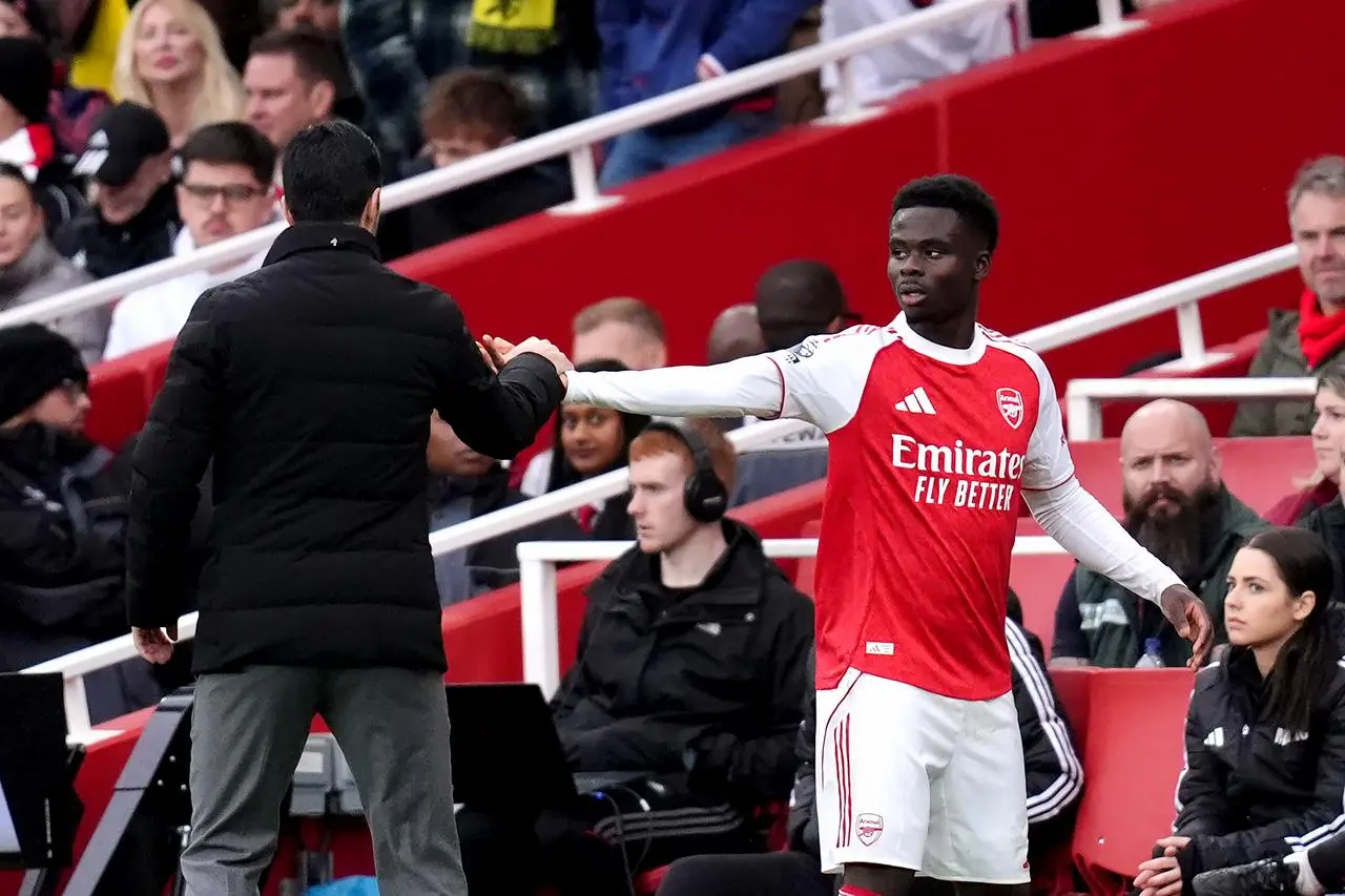 Arsenal’s Bukayo Saka (right) greets manager Mikel Arteta