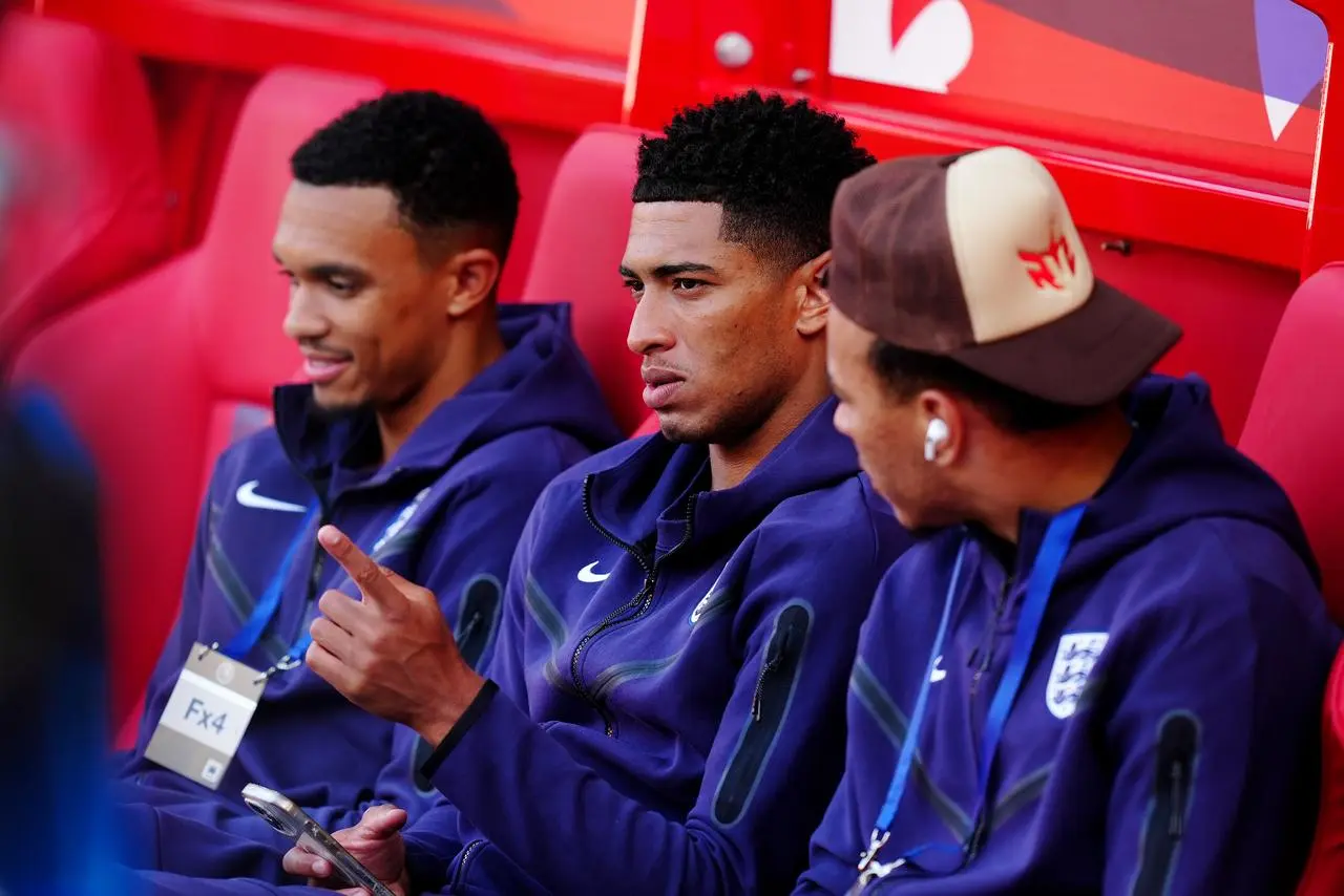 Jude Bellingham sits on a bench with Trent Alexander-Arnold