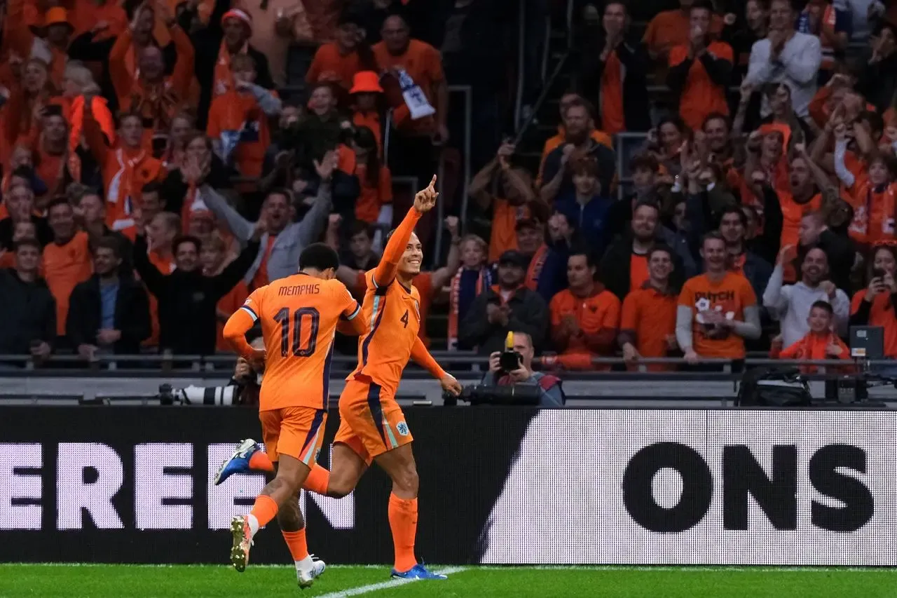 Netherlands’ Virgil van Dijk celebrates with Memphis Depay after scoring for the Netherlands