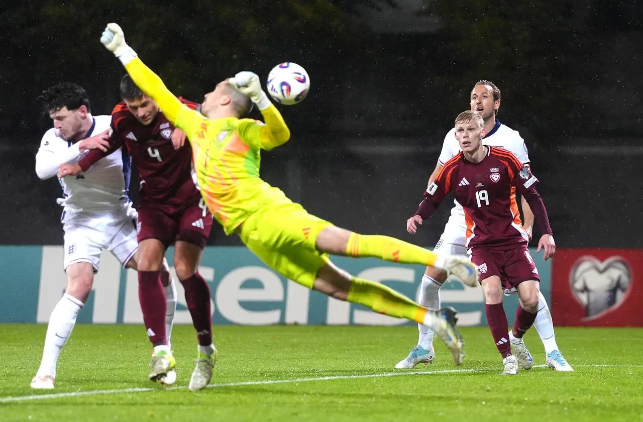 Latvia keeper Krisjanis Zviedris fails to cut out Djed Spence's cross, leading to an own goal by Maksims Tonisevs, right