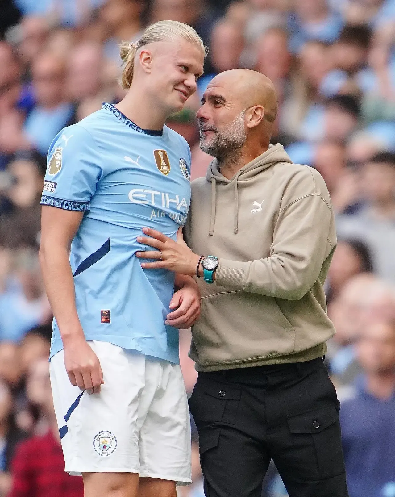 Pep Guardiola talks to Erling Haaland on the touchline during a game