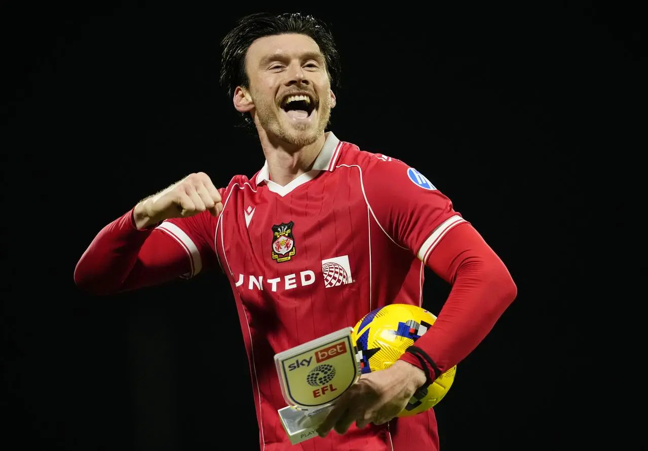 Wrexham’s Kieffer Moore celebrates with the match ball and the player of the match trophy after victory over Coventry